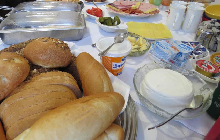 a table with a plate of bread and other foods at Villa Gradski Vrt in Osijek