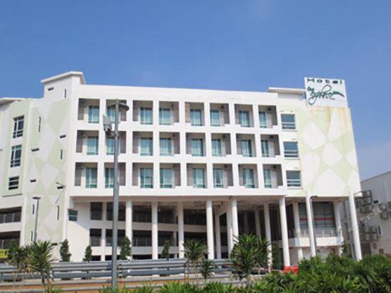 um grande edifício branco com um cartaz em The Explorer Hotel em Malaca