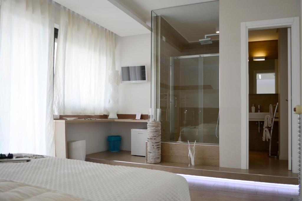 1 dormitorio con ducha de cristal y 1 cama en B&B Dimora Silvestri, en Polignano a Mare