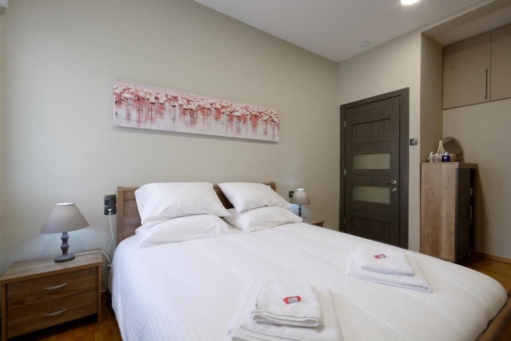 een slaapkamer met een groot wit bed en handdoeken bij “ZEUS”, STYLISH LUXURY BUSINESS SUITE in the heart of Athens. in Athene