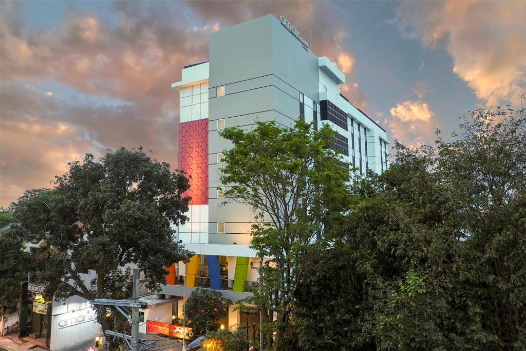 a tall white building with a colorful facade at Amaris Hotel Sriwedari Solo in Solo