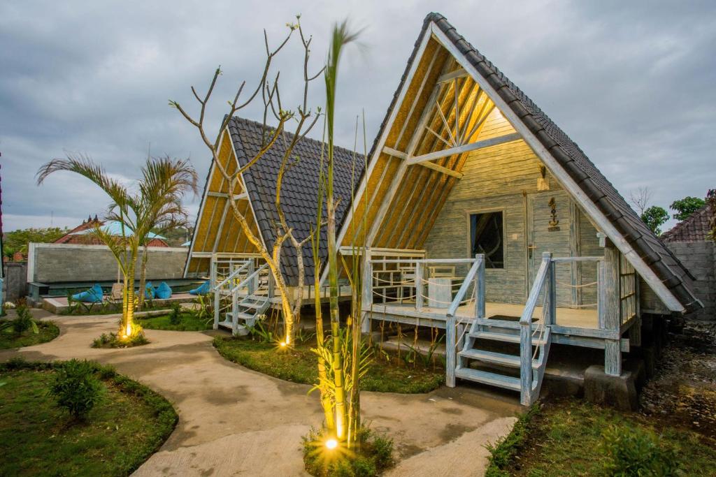 een tiny house met een veranda en een terras bij D'Yuki Huts Lembongan in Nusa Lembongan