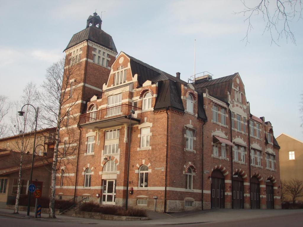 un gran edificio de ladrillo rojo con una torre de reloj en STF Östersund Ledkrysset en Östersund