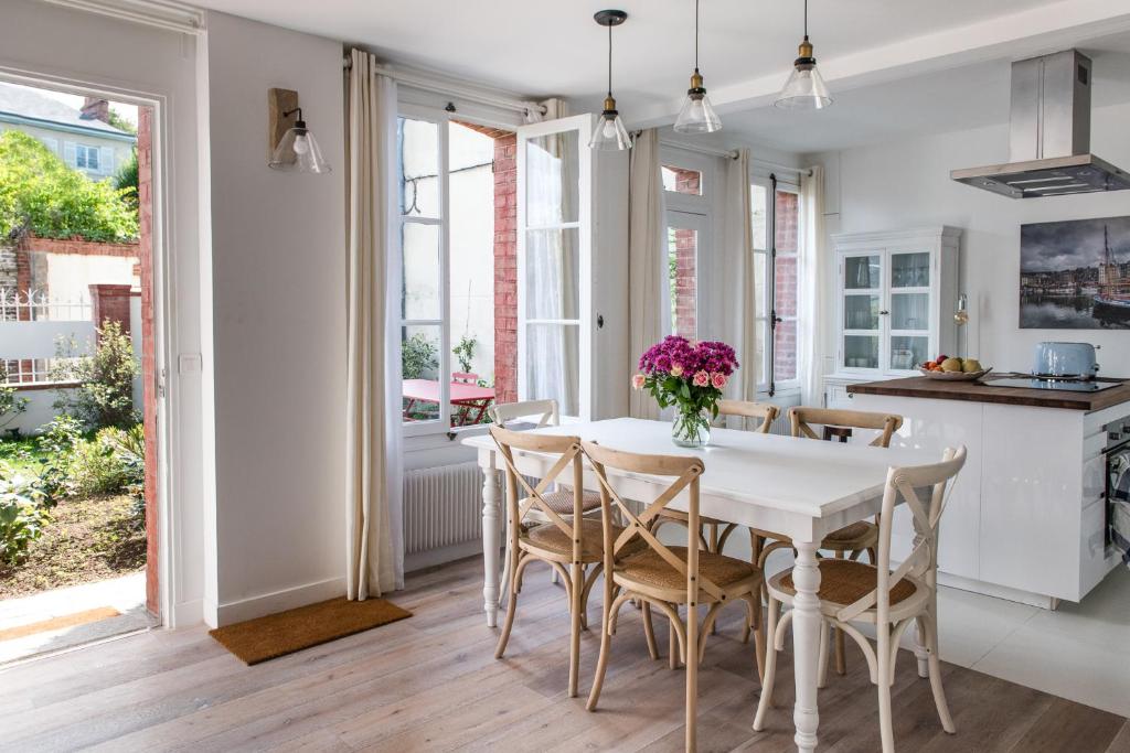una cucina e una sala da pranzo con tavolo e sedie bianchi di La maison de Colette, Traditionnelle Maison d'Armateur de 3 chambres et 3 salles de bains a Honfleur