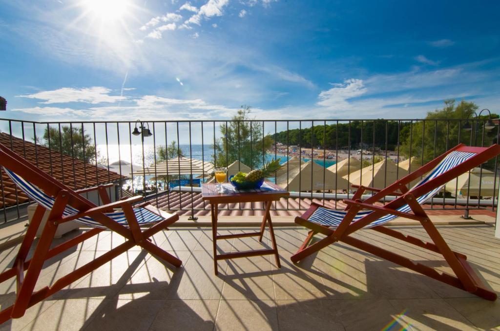 a patio with two chairs and a table on a balcony at Apartment Primosten Adiomare in Primo&scaron;ten