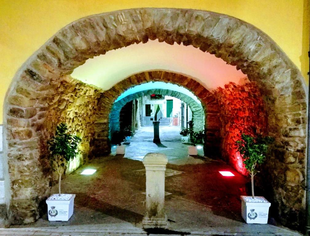 ein Torbogen in einem Gebäude mit Pflanzen in Töpfen in der Unterkunft Sotto L'Arco in Santo Stefano di Camastra