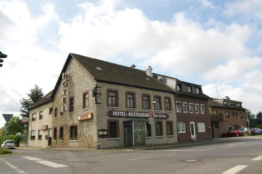 un viejo edificio de ladrillo en la esquina de una calle en Hotel Zur Heide, en Aachen