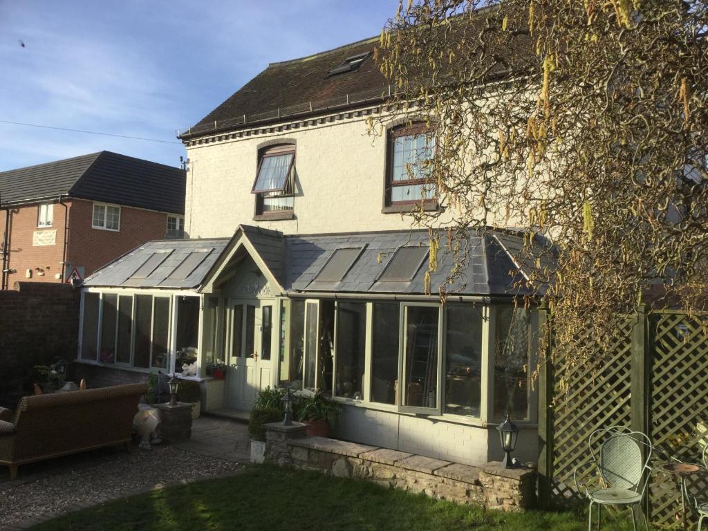 a house with a conservatory with sliding glass doors at Henwick house accommodation in Ludlow
