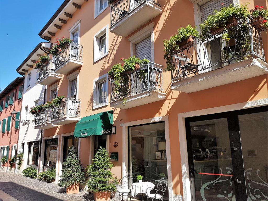 um edifício com vasos de plantas nas varandas em Albergo Fiorita em Bardolino