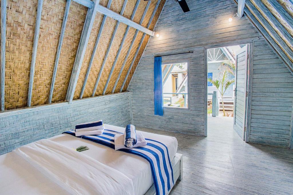 a bedroom with a large bed with towels on it at D'Yuki Huts Lembongan in Nusa Lembongan