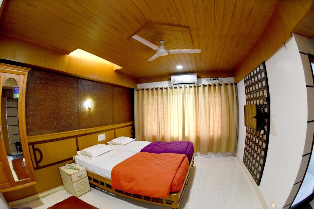 Hotel Sharada International tesisinde bir odada yatak veya yataklar