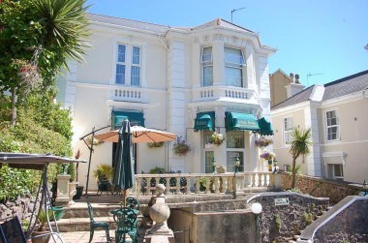 a house with a balcony and a garden at Kelvin House in Torquay