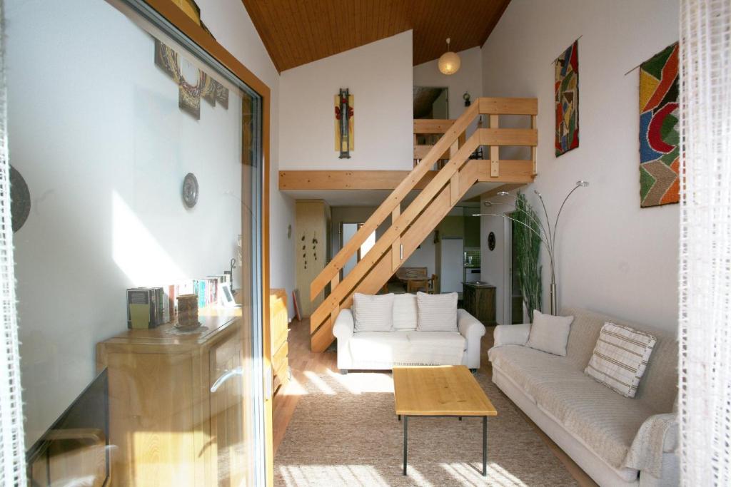 sala de estar con sofá blanco y escalera en I dr Rehwiesa A32, en Arosa