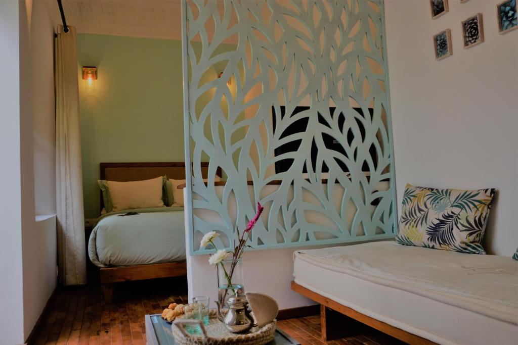 Habitación con dormitorio con cama y espejo. en Dar Korsan, en Rabat