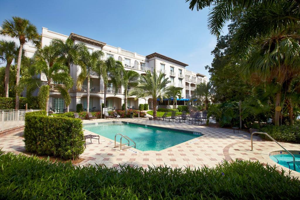 a swimming pool in front of a large building at Trianon Bonita Bay Hotel in Bonita Springs