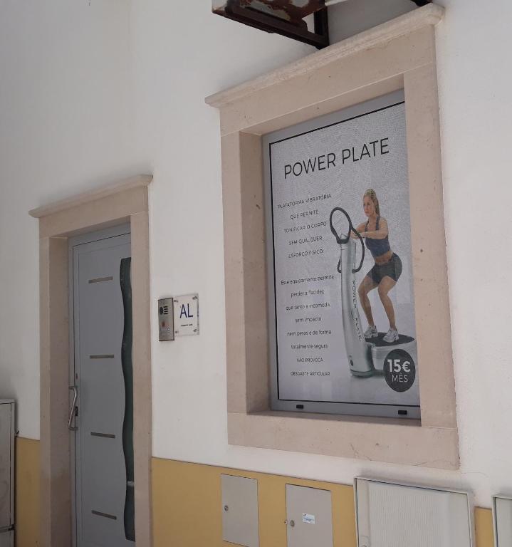 a poster of a woman on a power plate on a wall at Ocean Breeze guesthouse in Nazaré