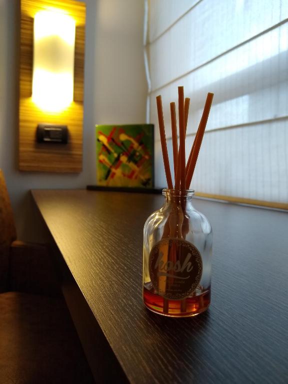 a glass bottle with sticks in it sitting on a table at Scala 68 in Bogotá
