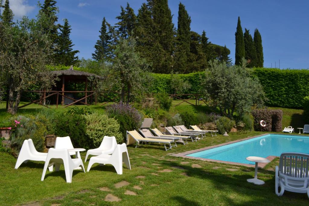 einen Garten mit Stühlen und einem Pool in der Unterkunft Terre di Melazzano - Le Case di Chiara in Greve in Chianti