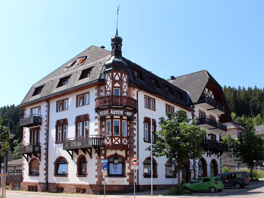 duży biały budynek z czarnym dachem w obiekcie Hotel Neustädter Hof w mieście Titisee-Neustadt