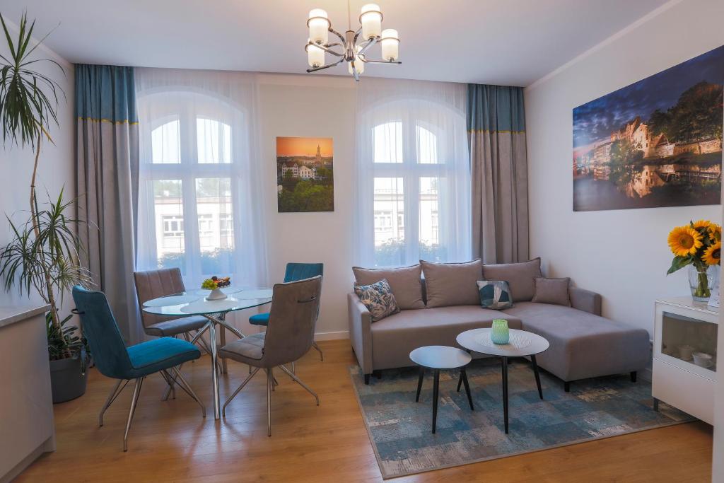salon z kanapą i stołem w obiekcie Proseco Apartments -Self check-in- w mieście Opole
