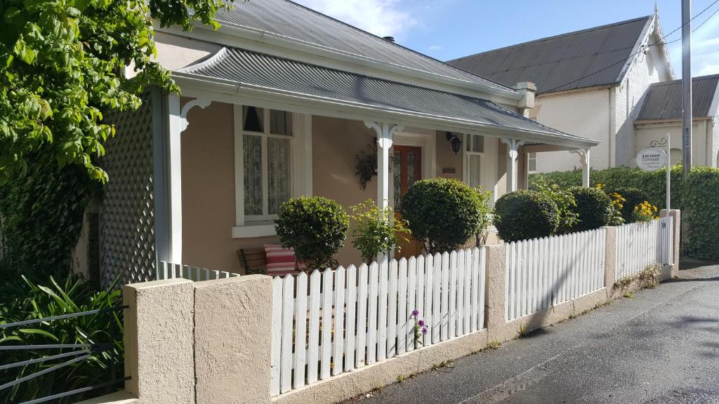 a white fence in front of a house at Arendon Cottage in Evandale