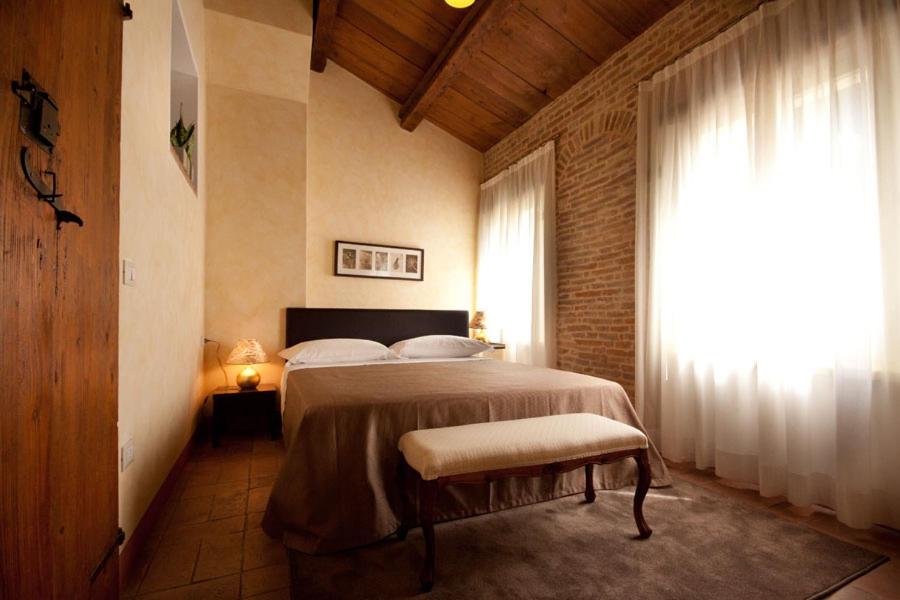 una camera con un grande letto e una finestra di Residenza i Platani a SantʼArcangelo di Romagna