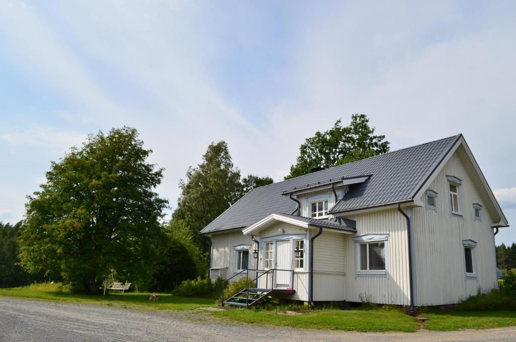 a white house with a gray roof on a street at Luntinmäen omakotitalo in Keskikylä