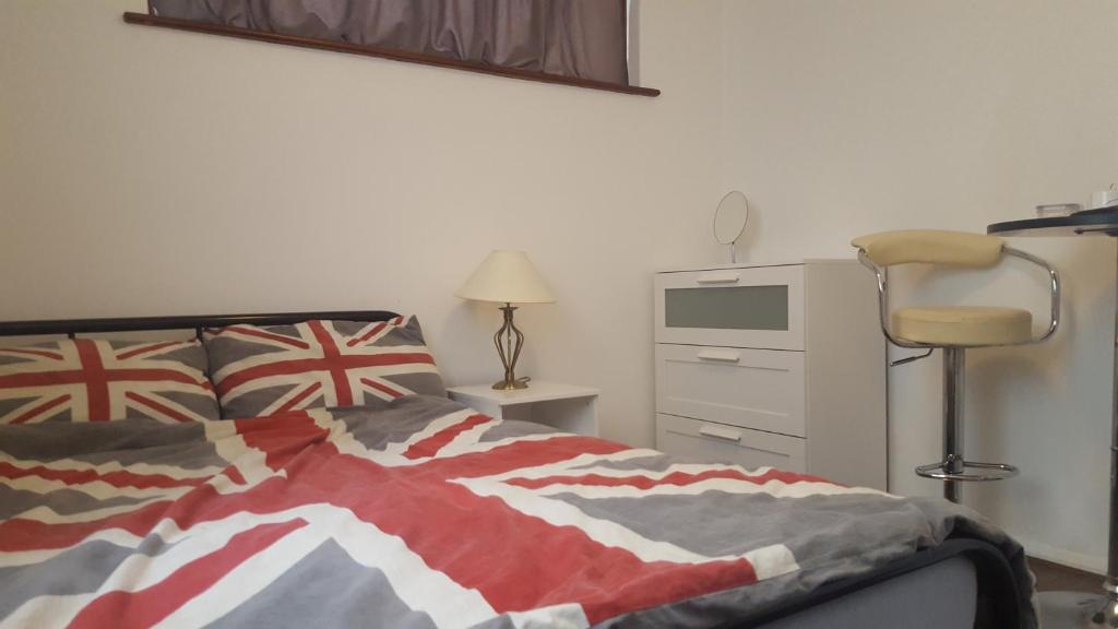 ein Schlafzimmer mit einem Bett und einem Schreibtisch mit einem Stuhl in der Unterkunft The Heart Of Stratford..! in London