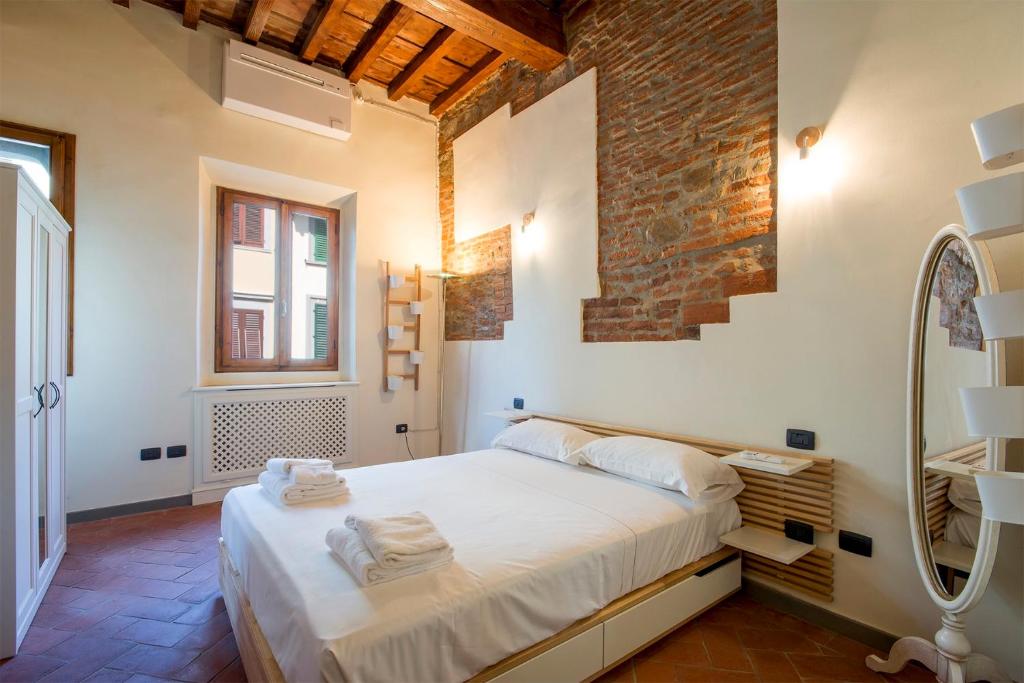 a bedroom with a large bed and a mirror at Ognissanti apartment in Florence