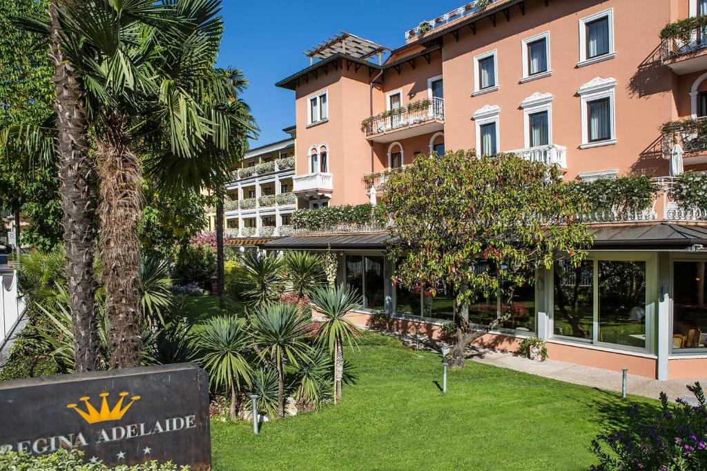 Blick auf die Vorderseite eines Gebäudes mit einem Schild in der Unterkunft Regina Adelaide Hotel & SPA in Garda