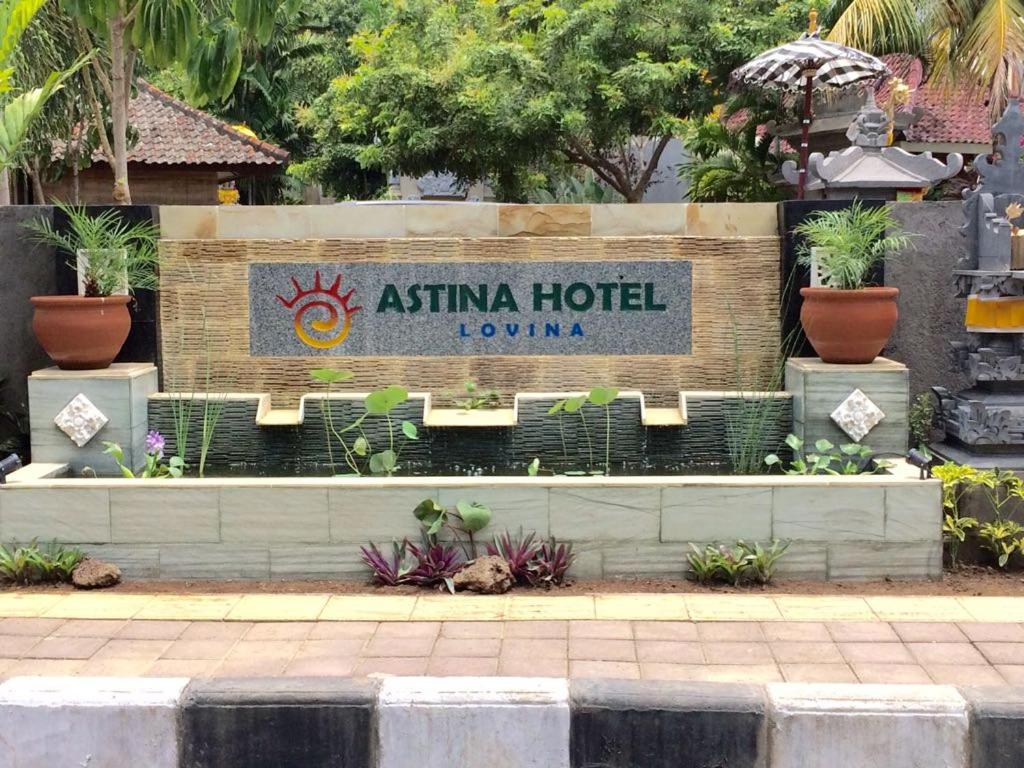 a sign for an asian hotel with plants at Astina Hotel in Lovina