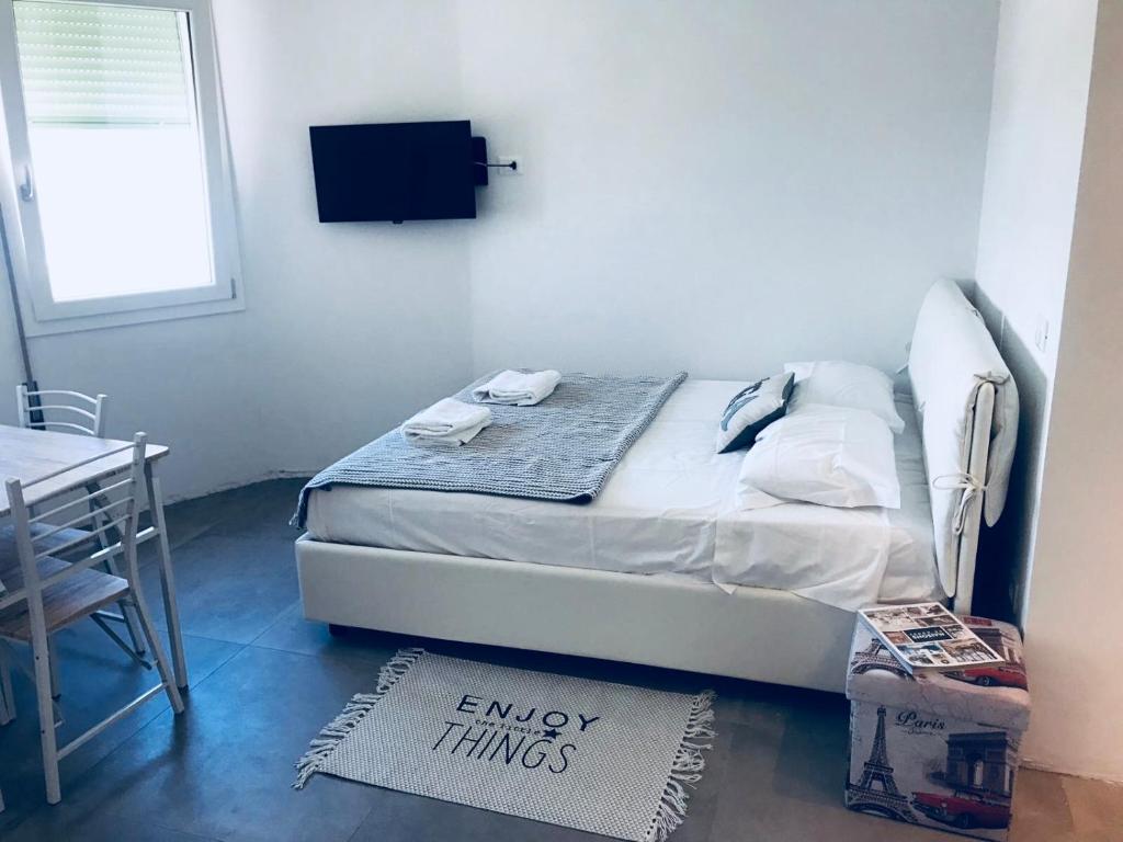 een slaapkamer met een bed, een bureau en een raam bij appartamento piazza mazzini in Lido di Jesolo