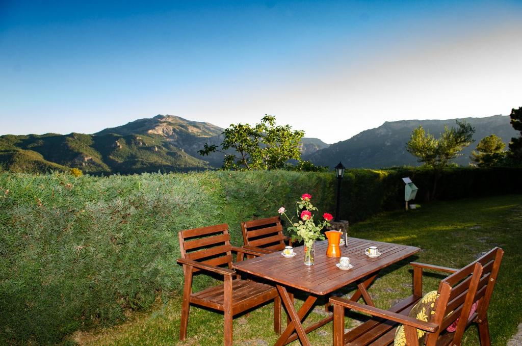 a wooden table with flowers on it with two chairs at Casas Rurales Mirador del Mundo in Yeste
