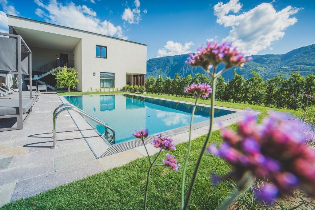 eine Villa mit einem Pool und Blumen in der Unterkunft Sinnergut in Nals