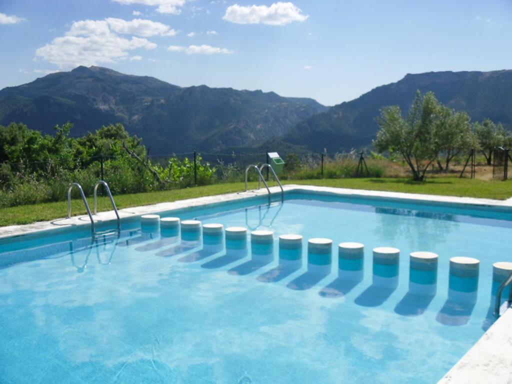 a swimming pool with mountains in the background at Casas Rurales Mirador del Mundo in Yeste