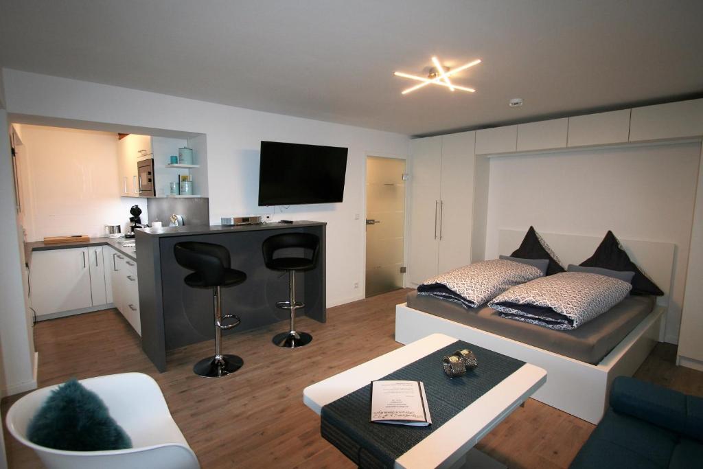 a living room with a bed and a desk and a kitchen at Alpenflair Ferienwohnungen Whg 106 in Oberstdorf
