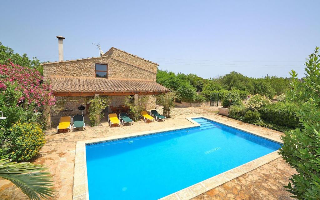 a swimming pool in front of a house at Finca Can Blanc 018 by Mallorca Charme in Lloret de Vistalegre