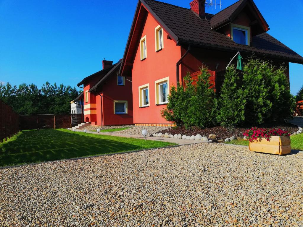 キェルツェにあるAgroturystyka "U Dyzia"の赤い家と砂利道のある家