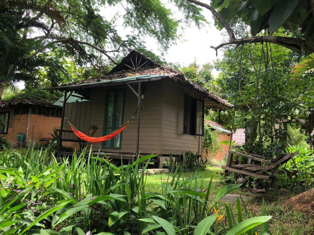 een klein huis met een rode hangmat ervoor bij Bannamhoo Bungalows in Pai