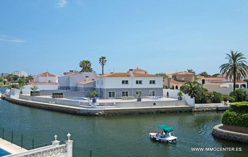 a boat in a river next to a house at LV02 in Empuriabrava