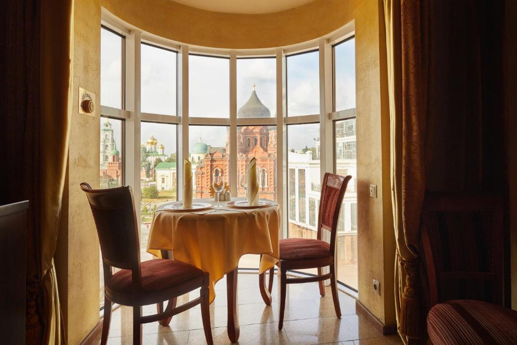 a table and chairs in a room with a large window at Armenia Hotel in Tula