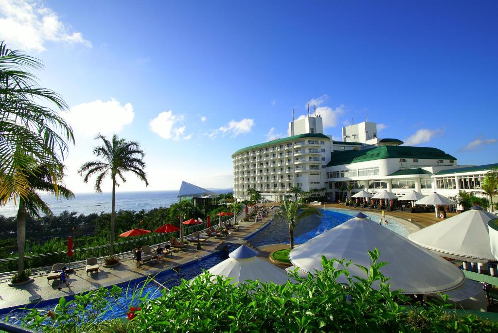 un complejo con piscina y un edificio en Okinawa Kariyushi Beach Resort Ocean Spa en Onna