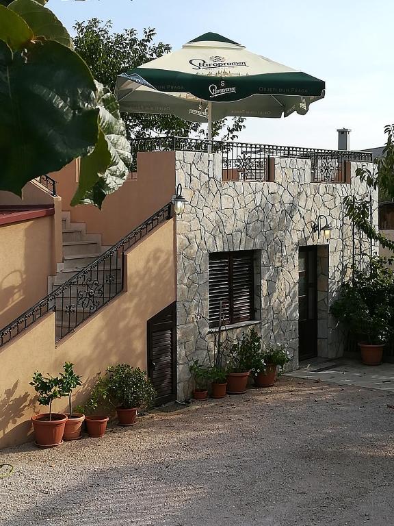 a green umbrella sitting on the side of a building at Apartman Nada in Kornić