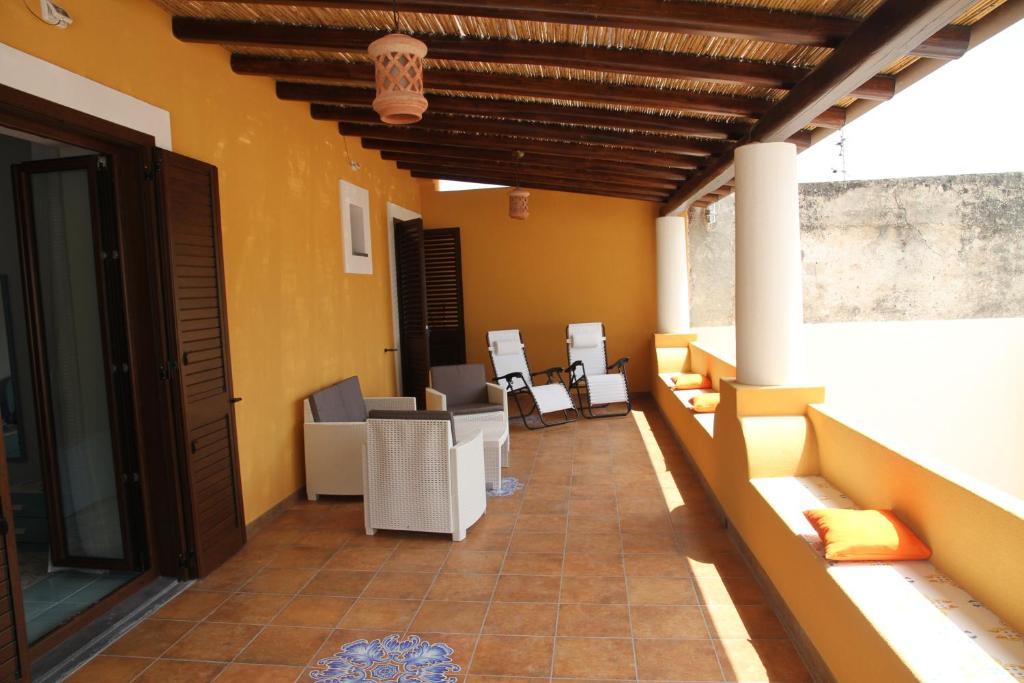 un patio con sedie e tavoli in un edificio di Appartamento Malvasia a Canneto