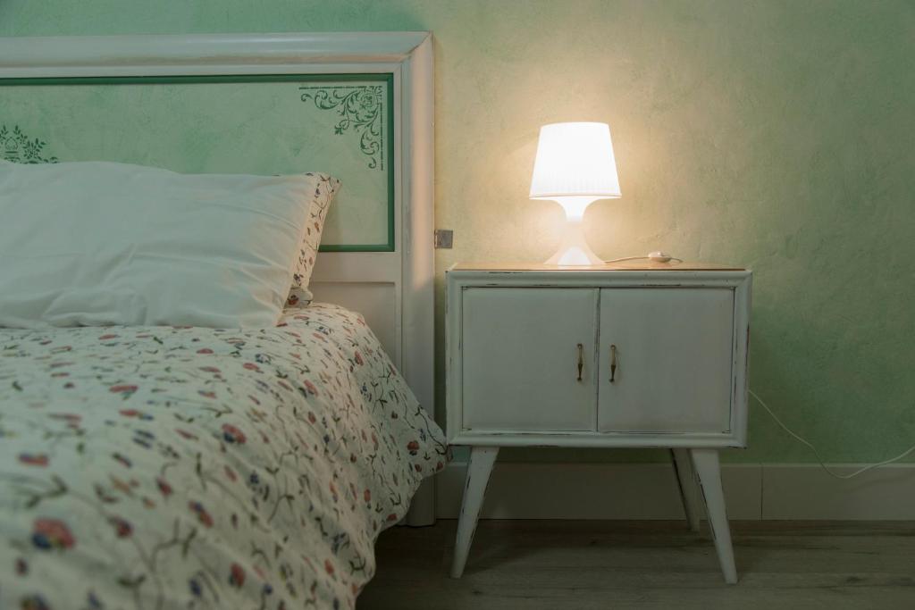 a bedroom with a bed with a lamp on a night stand at Le Camere di Casa Cassandra in Perugia
