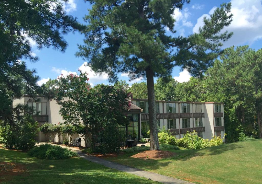 un edificio con un árbol delante en The Inn at Houndslake, en Aiken