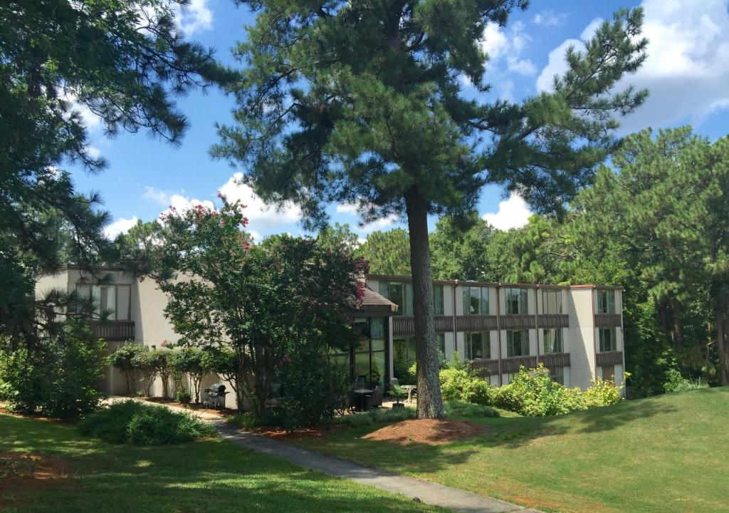 un edificio con un árbol delante de él en The Inn at Houndslake en Aiken