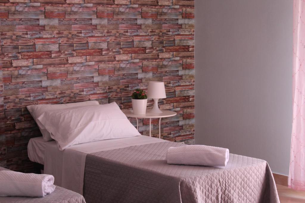 a bedroom with a brick wall and a bed at Casa Nicolas in Rome