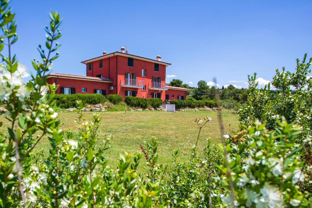 a red house in the middle of a field at Villa Liburnia in Livorno
