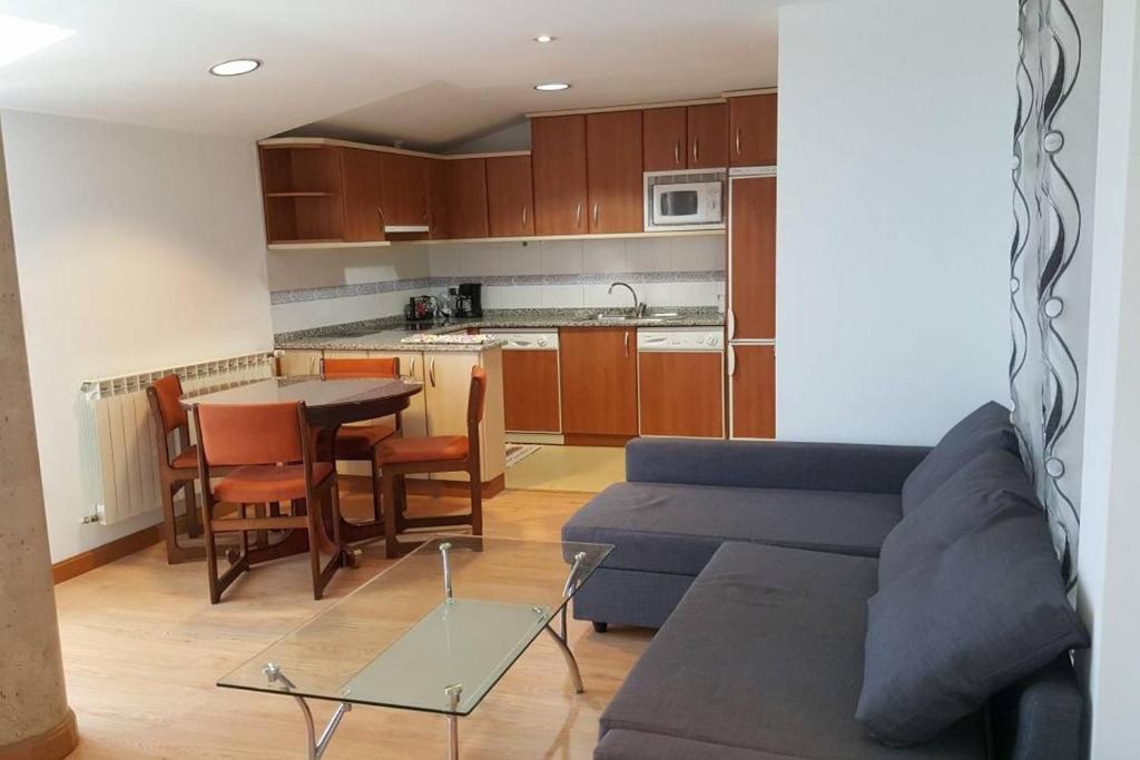 un soggiorno con divano e tavolo e una cucina di Apartamentos Vive Soria a Soria